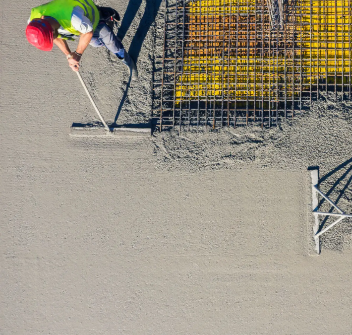 man smoothing out poured concrete